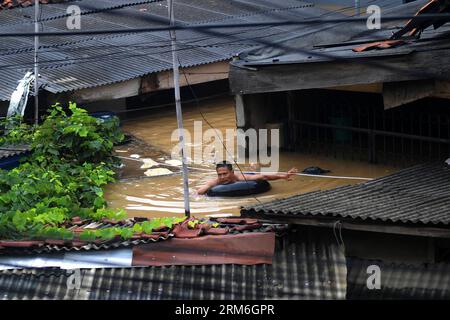 (140113) -- GIACARTA, 13 gennaio 2014 (Xinhua) -- Un uomo nuota nell'acqua alluvionale con uno pneumatico a Giacarta, Indonesia, 13 gennaio 2013. La capitale indonesiana Giacarta sta prendendo precauzioni per garantire la sicurezza delle persone da possibili inondazioni più grandi, poiché finora oltre 5.000 persone sono state sfollate dalle acque, ha detto un funzionario qui lunedì. [Xinhua/veri Sanovri)(ctt) INDONESIA-GIACARTA-FLOOD PUBLICATIONxNOTxINxCHN Giacarta 13 gennaio 2014 XINHUA un uomo nuota nell'acqua alluvionale con un pneumatico a Giacarta Indonesia 13 gennaio 2013 capitale indonesiana Giacarta STA prendendo precauzioni per garantire la sicurezza delle celebrità fr Foto Stock