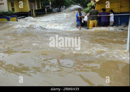 (140113) -- GIACARTA, 13 gennaio 2014 (Xinhua) -- le persone si sono imbattute in una strada allagata a Tangerang, provincia di Banten, Indonesia, 13 gennaio 2014. (Xinhua/Zulkarnain) INDONESIA-BANTEN-FLOOD PUBLICATIONxNOTxINxCHN Giacarta 13 gennaio 2014 XINHUA Celebrities Calf attraverso una strada allagata nella provincia di Banten Indonesia 13 gennaio 2014 XINHUA Indonesia Banten Flood PUBLICATIONxNOTxINxCHN Foto Stock