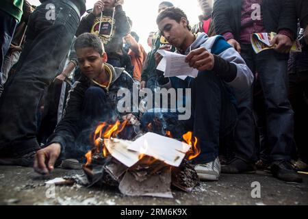 (140117) -- CAIRO, 17 gennaio 2014 (Xinhua) -- i manifestanti antimilitari bruciano copie della nuova bozza costituzionale durante una marcia al Cairo, in Egitto, 17 gennaio 2014. Almeno una persona è stata uccisa venerdì in Egitto durante gli scontri tra la polizia e i sostenitori del presidente islamista spodestato Mohamed Morsi, riportato sul sito ufficiale di al-Ahram. (Xinhua/Amru Salahuddien) EGITTO-CAIRO-TUMULTO PUBLICATIONxNOTxINxCHN Cairo 17 gennaio 2014 XINHUA Anti-Military Contestants brucia copie del nuovo progetto di Costituzione durante una marcia al Cairo Egitto 17 gennaio 2014 almeno una celebrità che HA UCCISO venerdì ad es Foto Stock