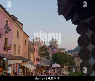 Negozi di souvenir nella colorata città vecchia di Mostar e sito patrimonio dell'umanità dell'UNESCO in una serata estiva piena di turisti. Bosnia ed Erzegovina, 26 agosto 2023. Foto Stock