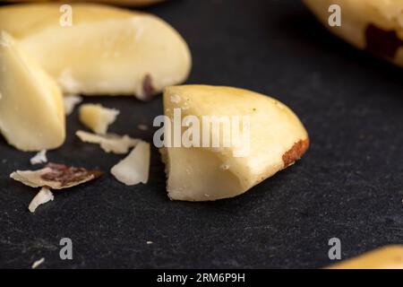 Noci brasiliane fresche sbucciate dalla conchiglia sulla tavola, frutta brasiliana sbucciata sparsa sulla tavola Foto Stock