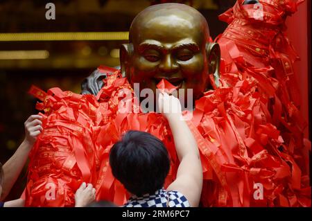 (140124) -- SINGAPORE, 24 gennaio 2014 (Xinhua) -- le persone legano nastri di preghiere su un Buddha in un mercato cinese di Capodanno lunare a Singapore, 24 gennaio 2014. (Xinhua/Then Chih Wey)(bxq) CAPODANNO SINGAPORE-LUNAR PUBLICATIONxNOTxINxCHN Singapore 24 gennaio 2014 celebrità di XINHUA Tie nastri di preghiere SU un Buddha IN un mercato cinese di Capodanno lunare a Singapore 24 gennaio 2014 XINHUA poi Chih Wey Singapore Capodanno lunare PUBLICATIONxNOTxINxCHN Foto Stock