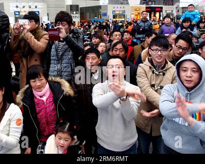 (140127) -- SHANGHAI, 27 gennaio 2014 (Xinhua) -- i passeggeri sono entusiasti dell'improvvisa esibizione di flash mob nella hall della stazione ferroviaria di Hongqiao a Shanghai, Cina orientale, 27 gennaio 2014. Un gruppo di flash mob si è riunito lunedì alla stazione ferroviaria di Hongqiao e ha cantato e ballato per i passeggeri che stavano tornando a casa durante la corsa di viaggio del Festival di Primavera. (Xinhua/Chen Fei) (zgp) CINA-SHANGHAI-TRAVEL RUSH-FLASH MOBS (CN) PUBLICATIONxNOTxINxCHN Shanghai Jan 27 2014 XINHUA Passenger Cheer for the Sudden Performance of Flash Mobs AT the lobby of Hongqiao Railway Station in Shangh Foto Stock