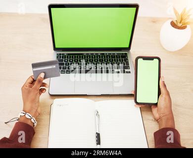 Donna, mani e laptop con mockup con schermo verde del telefono e carta di credito nello shopping online o nelle banche in ufficio. Donna con debito sul computer Foto Stock