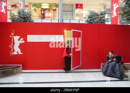 (140205) -- BERLINO, 5 febbraio 2014 (Xinhua) -- un paio riposa di fronte a una bacheca del prossimo Berlinale Film Festival in un centro commerciale di Potsdamer Platz a Berlino, Germania, il 5 febbraio 2014. Il 64° Festival del Cinema di Berlinale si svolgerà dal 5 al 16 febbraio presso Potsdamer Platz di Berlino, presentando un totale di 409 film, con 20 in competizione per l'Orso d'Oro. (Xinhua/Zhang fan) GERMANIA-BERLINO-BERLINALE FILM FESTIVAL PUBLICATIONxNOTxINxCHN Berlino 5 febbraio 2014 XINHUA una COPPIA riposa di fronte a una bacheca del prossimo Berlinale Film Festival in un centro commerciale di vasi Foto Stock