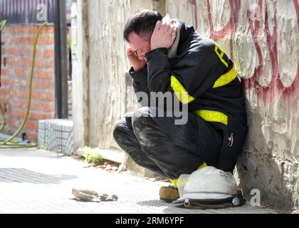 (140205) -- BUENOS AIRES, 5 febbraio 2014 (Xinhua) -- Un vigile del fuoco fa una telefonata sul luogo dell'incendio di un magazzino a Barracas, Buenos Aires, capitale dell'Argentina, 5 febbraio 2014. Almeno cinque vigili del fuoco e due soccorritori sono morti mercoledì quando stavano estinguendo un incendio in un magazzino di documenti bancari di proprietà della montagna di ferro nella capitale. (Xinhua/TELAM) ARGENTINA-BUENOS AIRES-FIRE PUBLICATIONxNOTxINxCHN Buenos Aires 5 febbraio 2014 XINHUA un Vigili del fuoco effettua una chiamata telefonica PRESSO il sito di un incendio magazzino a Barracas Buenos Aires capitale dell'Argentina 5 febbraio 2014 almeno cinque vigili del fuoco e TW Foto Stock
