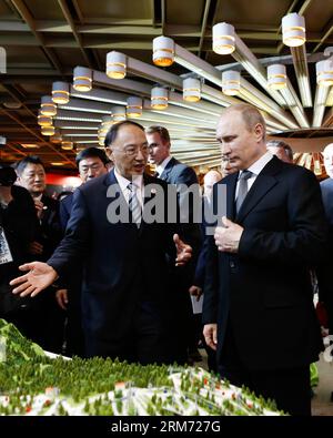 (140210) -- SOCHI, 10 febbraio 2014 (Xinhua) -- il presidente russo Vladimir Putin (R) ascolta come presidente del Comitato olimpico cinese e ministro dell'amministrazione generale dello sport in Cina Liu Peng introduce una tavola di sabbia che mostra le sedi di Zhang Jiakou, la città dei Giochi Olimpici invernali del 2022 durante una visita alla China House presso l'hotel Zhemchuzhina nel centro di Sochi, in Russia, 10 febbraio 2014. China House, il centro del Comitato Olimpico Cinese per accogliere gli ospiti, ha aperto qui il giovedì, come luogo di comunicazione culturale durante i Giochi Olimpici invernali di Sochi. (Xinhua/Ding Xu) Foto Stock