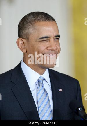 (140212) -- WASHINGTON, 12 febbraio 2014 (Xinhua) -- il presidente degli Stati Uniti Barack Obama lampeggia durante la firma di un ordine esecutivo per aumentare il salario minimo per i lavoratori a contratto federali nella stanza orientale della Casa Bianca a Washington D.C., negli Stati Uniti, 12 febbraio 2014. La mossa, annunciata per la prima volta durante il discorso sullo stato dell'Unione, aumenterà il salario minimo per gli appaltatori federali a 10,10 dollari all'ora dall'attuale tasso di 7,25 dollari. (Xinhua/Yin Bogu) U.S.-WASHINGTON-OBAMA-MINIMUM WAGE-ORDER PUBLICATIONxNOTxINxCHN Washington Feb 12 2014 XINHUA presidente degli Stati Uniti Barack Obama durante Signi Foto Stock