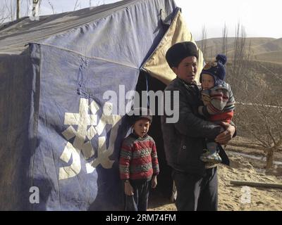 (140213) -- YUTIAN, 13 febbraio 2014 (Xinhua) -- gli abitanti del villaggio sfollati si trovano accanto a una tenda improvvisata nella cittadina di Aqqan, colpita dal terremoto, nella contea di Yutian, prefettura di Hotan, regione autonoma di Xinjiang Uygur della Cina nord-occidentale, 13 febbraio 2014. Un terremoto di magnitudo 7,3 che ha colpito la regione occidentale della Cina dello Xinjiang mercoledì pomeriggio ha colpito più di 7.800 persone, senza che siano state segnalate vittime. (Xinhua/Cao Zhiheng) (hdt) CHINA-XINJIANG-QUAKE (CN) PUBLICATIONxNOTxINxCHN Yutian Feb 13 2014 XINHUA sfollati paesani si trovano accanto a una tenda improvvisata nella Quake Hit Township a Yutia Foto Stock