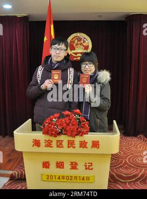 (140214) -- PECHINO, 14 febbraio 2014 (Xinhua) -- gli sposi novelli mostrano i loro certificati di matrimonio in un registro di matrimonio il giorno di San Valentino, così come il Chinese Traditional Lantern Festival a Pechino, capitale della Cina, 14 febbraio 2014. Molti sposi novelli hanno scelto di ottenere le licenze di matrimonio il giorno di San Valentino di quest'anno, in quanto coincide con il Festival delle Lanterne, il 15° giorno del primo mese del calendario lunare cinese. (Xinhua/Wu Guocai) (lfj) CINA-SAN VALENTINO-REGISTRAZIONE MATRIMONIO (CN) PUBLICATIONxNOTxINxCHN Pechino 14 febbraio 2014 gli sposi di XINHUA mostrano i loro certificati DI MATRIMONIO AD un MARRIAG Foto Stock