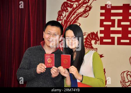 (140214) -- PECHINO, 14 febbraio 2014 (Xinhua) -- gli sposi novelli mostrano i loro certificati di matrimonio in un registro di matrimonio il giorno di San Valentino, così come il Chinese Traditional Lantern Festival a Pechino, capitale della Cina, 14 febbraio 2014. Molti sposi novelli hanno scelto di ottenere le licenze di matrimonio il giorno di San Valentino di quest'anno, in quanto coincide con il Festival delle Lanterne, il 15° giorno del primo mese del calendario lunare cinese. (Xinhua/Wu Guocai) (lfj) CINA-SAN VALENTINO-REGISTRAZIONE MATRIMONIO (CN) PUBLICATIONxNOTxINxCHN Pechino 14 febbraio 2014 gli sposi di XINHUA mostrano i loro certificati DI MATRIMONIO AD un MARRIAG Foto Stock