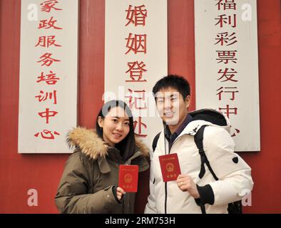 (140214) -- PECHINO, 14 febbraio 2014 (Xinhua) -- gli sposi novelli titolari dei loro certificati si esibiscono per delle foto in un registro di matrimonio il giorno di San Valentino, così come il Chinese Traditional Lantern Festival a Pechino, capitale della Cina, 14 febbraio 2014. Molti sposi novelli hanno scelto di ottenere le licenze di matrimonio il giorno di San Valentino di quest'anno, in quanto coincide con il Festival delle Lanterne, il 15° giorno del primo mese del calendario lunare cinese. (Xinhua/Sun Ruibo) (lfj) CINA-SAN VALENTINO-REGISTRAZIONE MATRIMONIO (CN) PUBLICATIONxNOTxINxCHN Pechino 14 febbraio 2014 XINHUA sposi novelli titolari dei loro certificati rappresentano per Foto Stock