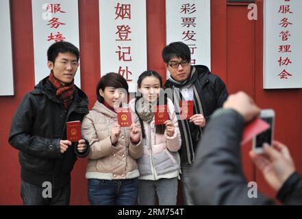 (140214) -- PECHINO, 14 febbraio 2014 (Xinhua) -- gli sposi novelli titolari dei loro certificati si esibiscono per delle foto in un registro di matrimonio il giorno di San Valentino, così come il Chinese Traditional Lantern Festival a Pechino, capitale della Cina, 14 febbraio 2014. Molti sposi novelli hanno scelto di ottenere le licenze di matrimonio il giorno di San Valentino di quest'anno, in quanto coincide con il Festival delle Lanterne, il 15° giorno del primo mese del calendario lunare cinese. (Xinhua/Sun Ruibo) (lfj) CINA-SAN VALENTINO-REGISTRAZIONE MATRIMONIO (CN) PUBLICATIONxNOTxINxCHN Pechino 14 febbraio 2014 XINHUA sposi novelli titolari dei loro certificati rappresentano per Foto Stock