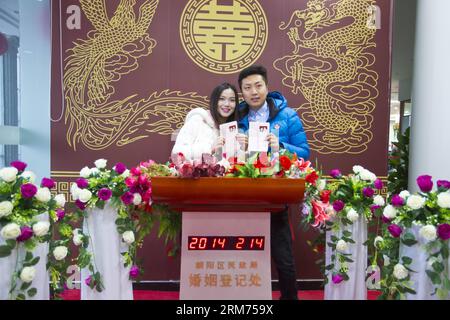 (140214) -- PECHINO, 14 febbraio 2014 (Xinhua) -- gli sposi novelli in possesso di certificati di matrimonio si esibiscono per le foto in un registro di matrimonio il giorno di San Valentino, così come il Chinese Traditional Lantern Festival a Pechino, capitale della Cina, 14 febbraio 2014. Molti sposi novelli hanno scelto di ottenere le licenze di matrimonio il giorno di San Valentino di quest'anno, in quanto coincide con il Festival delle Lanterne, il 15° giorno del primo mese del calendario lunare cinese. (Xinhua/Zhao Bing) (lfj) CINA-SAN VALENTINO-REGISTRAZIONE MATRIMONIO (CN) PUBLICATIONxNOTxINxCHN Pechino 14 febbraio 2014 XINHUA sposi novelli titolari di certificati di MATRIMONIO po Foto Stock