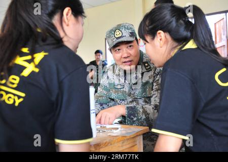 (140218) -- PITSANULOKE, Feb 18, 2014 (Xinhua) -- un membro dello staff del team medico da militare cinese dà una consulenza medica per la gente del posto in una scuola di provincia Pitsanuloke, Thailandia, Feb 18, 2014. La Cina ha inviato truppe per partecipare multilaterale di esercitazione militare Cobra Oro, guidata dagli Stati Uniti e la Tailandia per la prima volta. Il diciassettenne di forte squadra cinese prenderà parte a operazioni a comando e centro di coordinamento, assistenza tecnica, aiuto medico nonché le discussioni e gli scambi di militari scienze mediche, secondo ufficiali con l'ufficio esteri Foto Stock