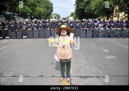 (140218) -- THAILANDIA, 18 febbraio 2014 (Xinhua) -- un manifestante anti-governativo si trova di fronte agli agenti di polizia antisommossa thailandesi vicino al Government House di Bangkok, capitale della Thailandia, il 18 febbraio 2014. La polizia tailandese martedì mattina ha iniziato a reclamare dai manifestanti anti anti-governativi cinque siti di raduno nella capitale Bangkok, lasciando quattro morti, tra cui un ufficiale di polizia e tre civili, altri 64 feriti negli scontri. (Xinhua/Gao Jianjun) TAILANDIA-BANGKOK-CLASH PUBLICATIONxNOTxINxCHN Paese Tailandese 18 febbraio 2014 XINHUA a Anti-governo si trova di fronte agli agenti della polizia antisommossa Tailandese vicino a Gover Foto Stock