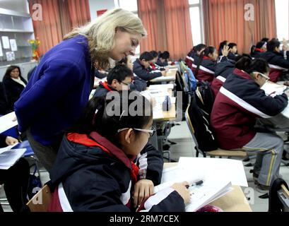 (140225) -- SHANGHAI, Feb. 25, 2014 (Xinhua) -- Elizabeth Truss, Sottosegretario di Stato del Parlamento britannico per l'istruzione e l'assistenza all'infanzia, esamina un esercizio studentesco a Shanghai, Cina orientale, 25 Feb. 2014. Per avere un'idea di un'educazione matematica di successo a Shanghai, una delegazione educativa britannica guidata da Elizabeth Truss ha visitato tre scuole a Shanghai martedì. (Xinhua/Liu Ying) (zkr) CHINA-SHANGHAI-ELIZABETH TRUSS-LESSON(CN) PUBLICATIONxNOTxINxCHN Shanghai Feb 25 2014 XINHUA Elizabeth Truss Sottosegretario di Stato del Parlamento britannico per l'istruzione e l'assistenza all'infanzia guarda a Stu Foto Stock