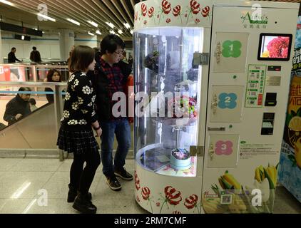 (140225) -- SHANGHAI, 25 febbraio 2014 (Xinhua) -- la gente guarda i mazzi di fiori all'interno di un distributore automatico di fiori in una stazione della metropolitana nella Shanghai orientale della Cina, 25 febbraio 2014. Attraverso il distributore automatico, le persone possono ottenere fiori comodamente dopo aver inserito il denaro per il pagamento. (Xinhua/Lai Xinlin) (mt) CHINA-SHANGHAI-FLOWER VENDING MACHINE (CN) PUBLICATIONxNOTxINxCHN Shanghai Feb 25 2014 le celebrità di XINHUA guardano i Bouquets of Flowers Inside A Flower vending Machine in una stazione della metropolitana nella Cina orientale Shanghai Feb 25 2014 attraverso il distributore automatico le celebrità POSSONO ottenere Fiori dopo Ins Foto Stock