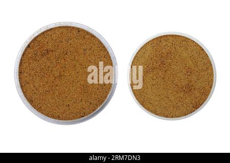 I campioni di sabbia di monazite o polvere di monazite vengono collocati su vassoi di piccole dimensioni su uno sfondo isolato Foto Stock