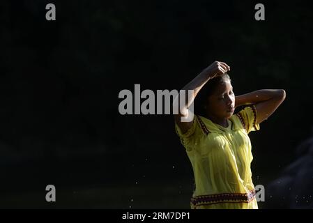 Una ragazza del gruppo etnico Ngabe Bugle bagni nel fiume Tabasara, nella regione indigena Ngabe Bugle, 450 km a ovest di Panama City, capitale di Panama, il 24 febbraio 2014. La regione indigena di Ngabe Bugle si trova nella regione occidentale di Panama e copre un'area di 6.968 km quadrati, con il 91% della sua popolazione che vive in estrema povertà. I leader indigeni della regione di Ngabe Bugle hanno dichiarato un allarme nazionale , a causa dell' avviso di sfratto emesso da una società che sta sviluppando il progetto idroelettrico Barro Blanco . Il progetto utilizzerà l'acqua del fiume Tabasara a Chiriqui provi Foto Stock