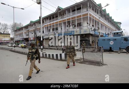 (140228) -- SRINAGAR, 28 febbraio 2014 (Xinhua) -- le truppe paramilitari indiane camminano in un mercato chiuso durante lo sciopero a Srinagar, capitale estiva del Kashmir controllato dagli indiani, il 28 febbraio 2014. Un arresto è stato osservato dalle aree a maggioranza musulmana del Kashmir controllato dagli indiani in seguito alla chiamata dei gruppi separatisti del Kashmir che cercavano l'identificazione di sette sospetti militanti uccisi dall'esercito indiano lunedì nel distretto di Kupwara, a circa 125 km a nord-ovest della città di Srinagar. Le proteste scoppiarono nella zona dopo che i civili sostenevano che gli uomini uccisi fossero civili. La polizia non ha identificato l'sl Foto Stock