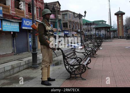 (140228) -- SRINAGAR, 28 febbraio 2014 (Xinhua) -- un'armata paramilitare indiana è in guardia in un mercato chiuso durante lo sciopero a Srinagar, capitale estiva del Kashmir controllato dagli indiani, il 28 febbraio 2014. Un arresto è stato osservato dalle aree a maggioranza musulmana del Kashmir controllato dagli indiani in seguito alla chiamata dei gruppi separatisti del Kashmir che cercavano l'identificazione di sette sospetti militanti uccisi dall'esercito indiano lunedì nel distretto di Kupwara, a circa 125 km a nord-ovest della città di Srinagar. Le proteste scoppiarono nella zona dopo che i civili sostenevano che gli uomini uccisi fossero civili. La polizia non ha la sua identita' Foto Stock