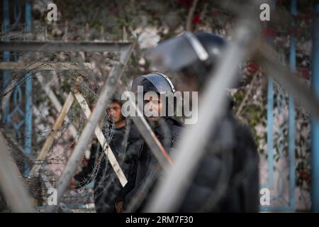 (140301) -- CAIRO, 1 marzo 2014 (Xinhua) -- la guardia della polizia antisommossa dietro filo spinato fuori dall'Accademia di polizia, dove un processo al presidente egiziano Mohamed Morsi espulso per le accuse di incitamento all'uccisione di manifestanti è previsto per l'apertura, al Cairo, capitale dell'Egitto, il 1° marzo 2014. (Xinhua/Pan Chaoyue) EGITTO-CAIRO-MORSI-PROCESSO PUBLICATIONxNOTxINxCHN Cairo 1 marzo 2014 la polizia antisommossa di XINHUA dietro Barbed Wire fuori dall'Accademia di polizia, dove un processo del presidente egiziano Mohamed Morsi ha spodestato per le accuse di incitamento all'uccisione dei manifestanti, È previsto per l'apertura a marzo nella capitale egiziana del Cairo Foto Stock