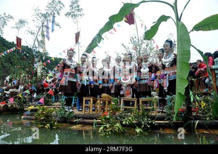 (140301) -- LIUZHOU, 1 marzo 2014 (Xinhua) -- i Dong partecipano a una parata di zattere di tronchi sul fiume Rongjiang nella municipalità di Meilin della contea autonoma di Sanjiang Dong a Liuzhou, nella regione autonoma di Guangxi Zhuang della Cina meridionale, 1 marzo 2014. I residenti del gruppo etnico Dong nella Meilin Township, un'area di produzione di legname, usavano spedire legname con zattere di legno lungo il fiume Rongjiang per la vendita nelle città a valle tra cui Wuzhou e Guangzhou. In passato, coloro che erano coinvolti nel settore del legname di solito hanno intrapreso un viaggio arduo a causa delle rapide del fiume e degli intricati terrai sottomarini Foto Stock