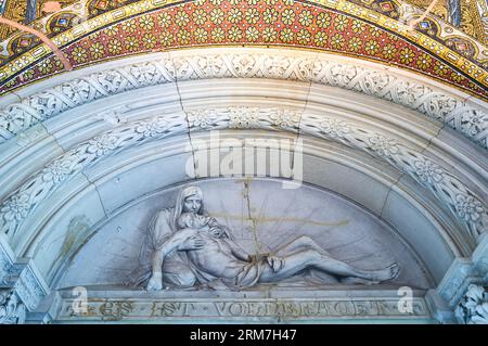 Berlino, Germania - Juky 30, 2019: Una scultura sacra sopra la porta dell'ingresso della chiesa commemorativa del Kaiser Wilhelm (l'iscrizione in germe Foto Stock