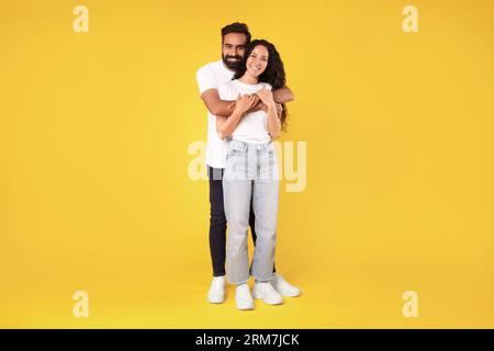 Bellissima coppia mediorientale che si posa su uno sfondo giallo Foto Stock