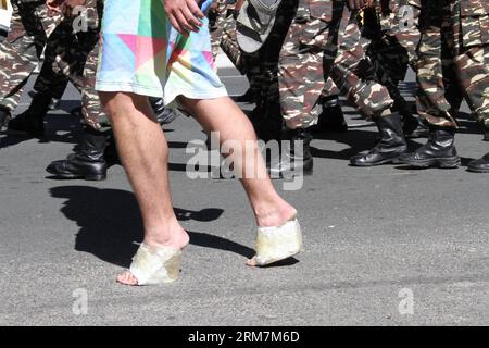 (140308) - WINDHOEK, 8 marzo 2014 (Xinhua) - Un uomo che indossa tacchi alti fatti da sé cammina con la banda militare della Namibia in una marcia per protestare contro la violenza di genere nella capitale della Namibia Windhoek, 8 marzo 2014. Decine di uomini con tacchi alti hanno partecipato al Men March to Stop Gender based Violence & Passion Killing in Namibia, nella capitale namibiana Windhoek, sabato. La marcia mira a protestare contro l'ondata di crimini mortali e di violenza contro le donne namibiane dall'inizio di quest'anno, durante il quale oltre dieci donne sono state uccise dai loro partner maschi nel paese dell'Africa sud-occidentale wi Foto Stock