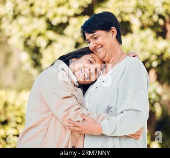 Mamma, donna e ritratto di abbraccio in giardino con amore e felicità nella giornata della mamma o legame con la madre in pensione. Felice, famiglia e abbraccio Foto Stock