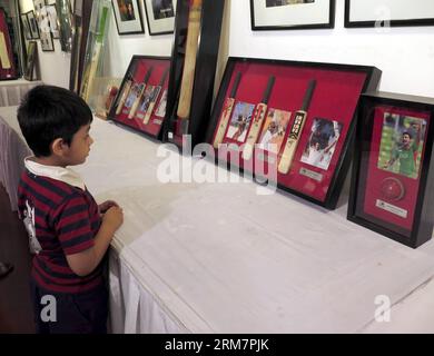 (140312) -- DACCA, 12 marzo 2014 (Xinhua) -- Un ragazzo visita la mostra di cimeli del cricket durante il Bangladesh Cricket Festival 2014 a Dacca, Bangladesh, 12 marzo 2014. I tre giorni del Bangladesh Cricket Festival 2014 sono iniziati dal 10 marzo davanti all'International Cricket Council (ICC) World Twenty 20 Championship in Bangladesh. (Xinhua/Shariful Islam) (SP) BANGLADESH-DHAKA-CRICKET FESTIVAL-EXHIBITION PUBLICATIONxNOTxINxCHN Dhaka 12 marzo 2014 XINHUA A Boy visita la Cricket Memorabilia Exhibition durante il Bangladesh Cricket Festival 2014 a Dhaka Bangladesh 12 marzo 2014 The Three Foto Stock