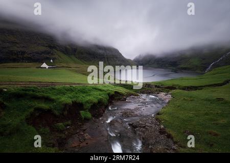 Isole Faroe - case sul tetto in erba nel piccolo villaggio Saksun, atmosfera nuvolosa Foto Stock