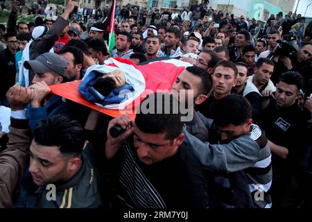 (140319) -- HEBRON, 19 marzo 2014 (Xinhua) -- Palestina porta il corpo del sedicenne palestinese Yussef Shawamreh durante il suo funerale nella città di Hebron in Cisgiordania il 19 marzo 2014. Shawamreh è stato colpito vicino al villaggio palestinese di al-Ramadin, a sud di Hebron, quando lui e tre dei suoi amici stavano tentando di attraversare la recinzione di separazione tra Israele e i territori palestinesi. (Xinhua/Mamoun Wazwaz) MIDEAST-HEBRON-FUNERAL PUBLICATIONxNOTxINxCHN Hebron 19 marzo 2014 XINHUA PALESTINESE porta il corpo di 16 anni adolescenti PALESTINESI Yussef durante le sue funerali nella Foto Stock