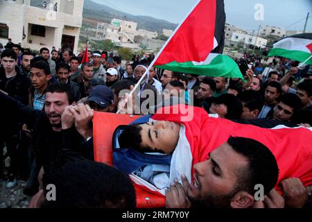 (140319) -- HEBRON, 19 marzo 2014 (Xinhua) -- Palestina porta il corpo del sedicenne palestinese Yussef Shawamreh durante il suo funerale nella città di Hebron in Cisgiordania il 19 marzo 2014. Shawamreh è stato colpito vicino al villaggio palestinese di al-Ramadin, a sud di Hebron, quando lui e tre dei suoi amici stavano tentando di attraversare la recinzione di separazione tra Israele e i territori palestinesi. (Xinhua/Mamoun Wazwaz) MIDEAST-HEBRON-FUNERAL PUBLICATIONxNOTxINxCHN Hebron 19 marzo 2014 XINHUA PALESTINESE porta il corpo di 16 anni adolescenti PALESTINESI Yussef durante le sue funerali nella Foto Stock