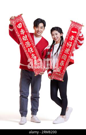 Felice giovane coppia con i distici che celebrano il capodanno cinese Foto Stock