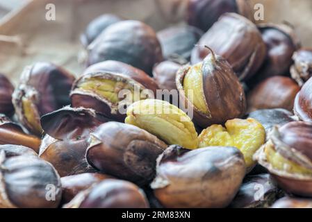 Castagne arrostite cotte in una padella a casa. Castagna dolce (Castanea sativa). Vista laterale e messa a fuoco selettiva Foto Stock