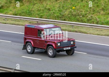 2005 Land Rover Defender 90 County TD5 Red LCV Hardtop Van Diesel 2495 cc che viaggia a velocità sostenuta sull'autostrada M6 a Greater Manchester, Regno Unito Foto Stock