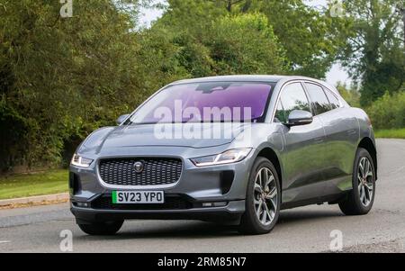 Whittlebury, Northants, Regno Unito - 26 agosto 2023: 2023 auto elettrica Jaguar i-pace grigia che viaggia su una strada di campagna inglese Foto Stock