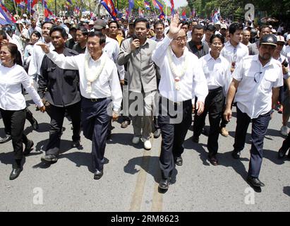 (140330) -- PHNOM PENH, 30 marzo 2014 (Xinhua) -- Sam Rainsy (2° R, fronte), presidente del partito di opposizione Cambodian National Rescue Party (CNRP), saluta i suoi sostenitori a Phnom Penh, Cambogia, 30 marzo 2014. Il CNRP domenica mattina ha tenuto una cerimonia religiosa in uno stupa commemorativo in un parco, appena a sud del Palazzo reale, in memoria delle vittime di un attacco di granata 17 anni fa. (Xinhua/Sovannara) CAMBOGIA-PHNOM PENH-17TH ANNIVERSARY-GRANADE ATTACK PUBLICATIONxNOTxINxCHN Phnom Penh marzo 30 2014 XINHUA Sat Rainsy 2nd r Front President of the opposition Cambodian National Rescue Party Foto Stock