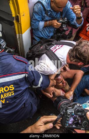 CARACAS, 3 aprile 2014 - un uomo ferito viene trasportato durante uno scontro tra manifestanti e membri della polizia Nazionale Bolivariana (PNB, per il suo acronimo in spagnolo), vicino all'Università centrale del Venezuela (UCV, per il suo acronimo in spagnolo), a Caracas, Venezuela, il 3 aprile 2014. (Xinhua/Manuel Hernandez)(ctt) VENEZUELA-CARACAS-SOCIETY-PROTEST PUBLICATIONxNOTxINxCHN Caracas 3 aprile 2014 a infortunato È trasportato durante uno scontro tra manifestanti e membri della polizia nazionale bolivariana PNB per il suo acronimo in spagnolo vicino all'Università centrale del Venezuela per la sua sigla Foto Stock