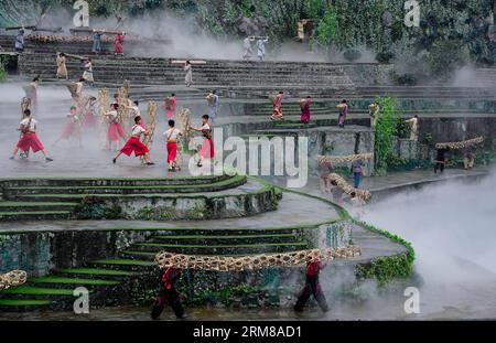 (140405) -- DUJIANGYAN, 5 aprile 2014 (Xinhua) -- le persone si esibiscono durante una cerimonia per offrire sacrifici all'acqua presso la diga di Dujiang, un antico ma ancora funzionante progetto di irrigazione, nella provincia del Sichuan della Cina sud-occidentale, 5 aprile 2014, il giorno del tradizionale Festival cinese di Qingming. Il più antico progetto di irrigazione del mondo fu costruito nel 256 a.C. dal governatore locale li Bing durante gli Stati combattenti (475-221 a.C.). La cerimonia si tiene ogni anno al Qingming Festival per pregare per il clima favorevole e commemorare i contributi di li Bing. (Xinhua/Jiang Hongjing) (wf) CHINA-SICHUAN-DUJ Foto Stock