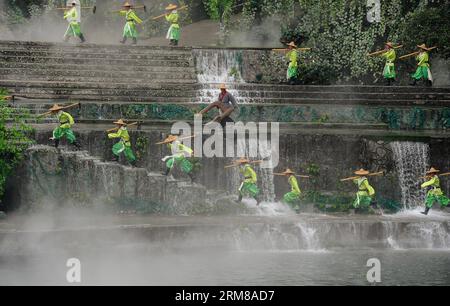 (140405) -- DUJIANGYAN, 5 aprile 2014 (Xinhua) -- le persone si esibiscono durante una cerimonia per offrire sacrifici all'acqua presso la diga di Dujiang, un antico ma ancora funzionante progetto di irrigazione, nella provincia del Sichuan della Cina sud-occidentale, 5 aprile 2014, il giorno del tradizionale Festival cinese di Qingming. Il più antico progetto di irrigazione del mondo fu costruito nel 256 a.C. dal governatore locale li Bing durante gli Stati combattenti (475-221 a.C.). La cerimonia si tiene ogni anno al Qingming Festival per pregare per il clima favorevole e commemorare i contributi di li Bing. (Xinhua/Jiang Hongjing) (wf) CHINA-SICHUAN-DUJ Foto Stock