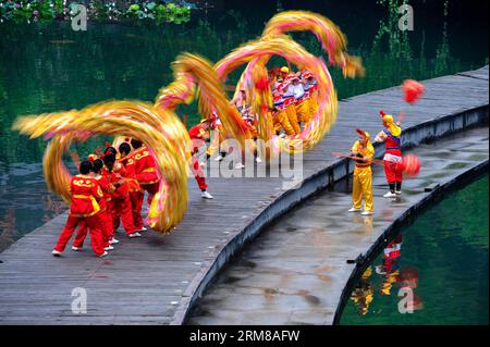 (140405) -- DUJIANGYAN, 5 aprile 2014 (Xinhua) -- le persone si esibiscono durante una cerimonia per offrire sacrifici all'acqua presso la diga di Dujiang, un antico ma ancora funzionante progetto di irrigazione, nella provincia del Sichuan della Cina sud-occidentale, 5 aprile 2014, il giorno del tradizionale Festival cinese di Qingming. Il più antico progetto di irrigazione del mondo fu costruito nel 256 a.C. dal governatore locale li Bing durante gli Stati combattenti (475-221 a.C.). La cerimonia si tiene ogni anno al Qingming Festival per pregare per il clima favorevole e commemorare i contributi di li Bing. (Xinhua/Jiang Hongjing) (wf) CHINA-SICHUAN-DUJ Foto Stock