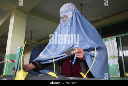 Una donna afghana lancia il suo voto in un centro elettorale a Kabul, Afghanistan, il 5 aprile 2014. I sondaggi per le elezioni presidenziali in Afghanistan si sono conclusi sabato e il conteggio delle schede è iniziato, hanno detto i funzionari elettorali del paese. Un totale di 6.218 centri elettorali sono rimasti aperti il giorno delle elezioni e circa 7 milioni di elettori ammissibili, il 36% di loro donne, avevano espresso i loro voti. (Xinhua/Ahmad Massoud) AFGHANISTAN-ELEZIONI PRESIDENZIALI-BALLOTING-CONCLUSION PUBLICATIONxNOTxINxCHN a una donna afghana pronuncia IL suo voto IN un centro di polling a Kabul Afghanistan IL 5 aprile 2014 il sondaggio Foto Stock