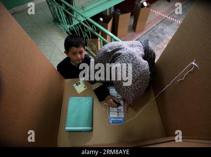 Una donna afghana lancia il suo voto in un centro elettorale a Kabul, Afghanistan, il 5 aprile 2014. I sondaggi per le elezioni presidenziali in Afghanistan si sono conclusi sabato e il conteggio delle schede è iniziato, hanno detto i funzionari elettorali del paese. Un totale di 6.218 centri elettorali sono rimasti aperti il giorno delle elezioni e circa 7 milioni di elettori ammissibili, il 36% di loro donne, avevano espresso i loro voti. (Xinhua/Ahmad Massoud) AFGHANISTAN-ELEZIONI PRESIDENZIALI-BALLOTING-CONCLUSION PUBLICATIONxNOTxINxCHN a una donna afghana pronuncia IL suo voto IN un centro di polling a Kabul Afghanistan IL 5 aprile 2014 il sondaggio Foto Stock