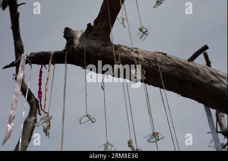 Gruppo simbolico di pezzi di vetro sulle corde e nastri colorati con il cielo e l'albero vecchio come sfondo. Astratto, tema decorativo Foto Stock