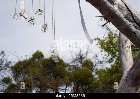 Gruppo di pezzi di vetro sulle corde e nastro bianco con il cielo come sfondo. Astratto, tema decorativo Foto Stock