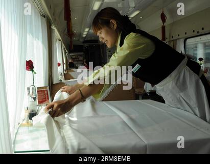 (140411) -- XINING, 11 aprile 2014 (Xinhua) -- Sun Linxue, una cameriera del treno T27 da Pechino a Lhasa, lavora sulla carrozza ristorante, 7 aprile 2014. Il treno T27/28 ha percorso 22,28 milioni di chilometri in sicurezza e ha trasportato oltre 790 milioni di passeggeri dal 1° luglio 2006 al 31 marzo 2014. (Xinhua/Tang Zhaoming) (zwy) TRENO CINA-PECHINO-TIBET-790 MILIONI DI PASSEGGERI (CN) PUBLICATIONxNOTxINxCHN Xining 11 aprile 2014 XINHUA Sun cameriera del treno T27 da Pechino a Lhasa lavora SUL vagone ristorante 7 aprile 2014 il treno T27 28 ha percorso 22 28 milioni di chilometri in sicurezza e ha trasportato oltre milioni di passeggeri fr Foto Stock